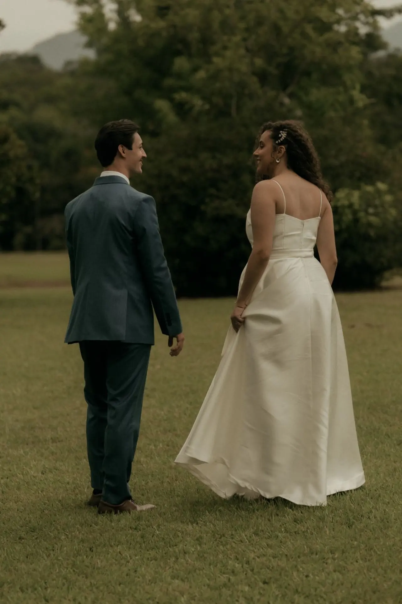 Una pareja pasea junta entre árboles durante su boda